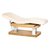 Cream-colored SPA lounger Sillon Comfort with light brown base, used as beauty salon furniture for client relaxation.