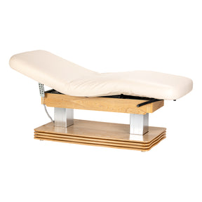 Cream-colored SPA lounger Sillon Comfort with light brown base, used as beauty salon furniture for client relaxation.
