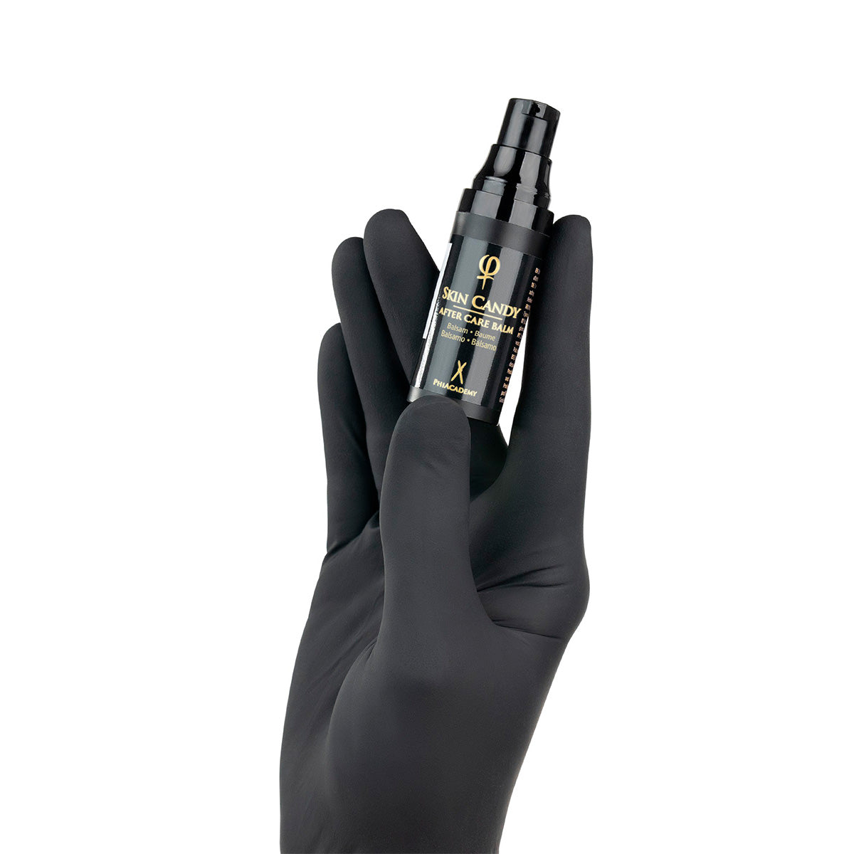 PhiAcademy Skin Candy After Care Balm — aftercare balm bottle held in a gloved hand